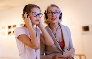 Older woman and young girl wearing headset at a museum