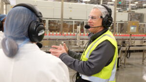 Tour guide communicates with visitor using hands-free headset with microphone.