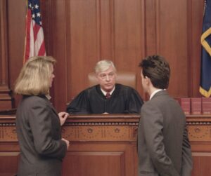 Two attorneys talking with the judge in a courtroom